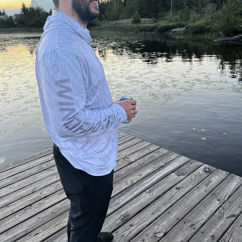 Worker wearing WindRider Hooded Helios long-sleeve cooling shirt on dock in warm conditions