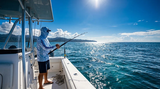 angler on a center console boat offshore, bright blue Pacific water behind them, wearing a long-sleeve hooded UPF fishing shirt, mid-morning sun directly overhead