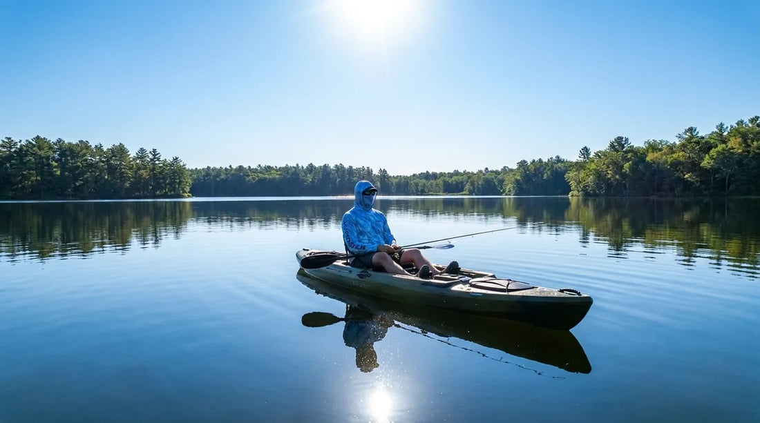 kayak angler paddling on calm lake at midday, bright overhead sun, wearing hooded long-sleeve sun shirt, fishing rod across lap, water reflecting intense light at face level