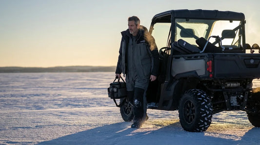 angler stepping out of a side-by-side UTV on a frozen lake at dawn, ice auger and fishing rods in the back, wide open ice expanse, low winter sun